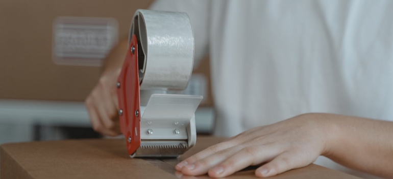 Picture of a person taping a box shut